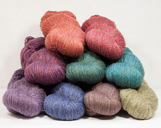 Stack of colorful yarn skeins on a white background