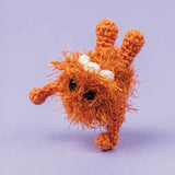 Crocheted creature with assembly instructions on a purple background