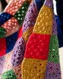 Colorful crocheted blanket with text on a book page