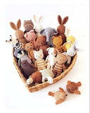 Collection of knitted animals in a basket with text on the left side.