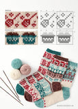 A knitting pattern booklet or kit page showing Fair Isle sock designs, with swatches, knit stitch diagrams, and three finished patterned socks laid on a white background with yarn balls and knitting needles.