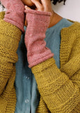 Person wearing a mustard yellow knitted cardigan with pink sleeves, text on a yellow background