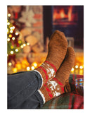 Knitting pattern leaflet for 'Santa's Helper' with a person wearing brown socks with red and white patterns, sitting by a fireplace.