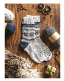 Knitted socks with yarn and tools on a wooden surface, accompanied by knitting instructions.