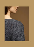 A close-up of a sweater's texture on a brown background.