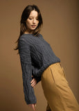 Woman wearing a blue crocheted sweater.