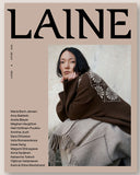 A magazine cover titled LAINE, featuring a model in a brown knit sweater and light gray skirt, set against a beige background with black typography.