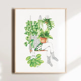 Framed artwork of a person sitting with plants on a white wall
