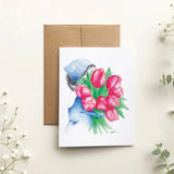 Greeting card with a design of a person holding pink tulips, surrounded by white flowers on a light background.
