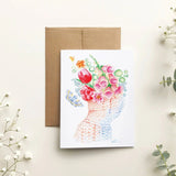 Greeting card with floral design on a light background with decorative branches.